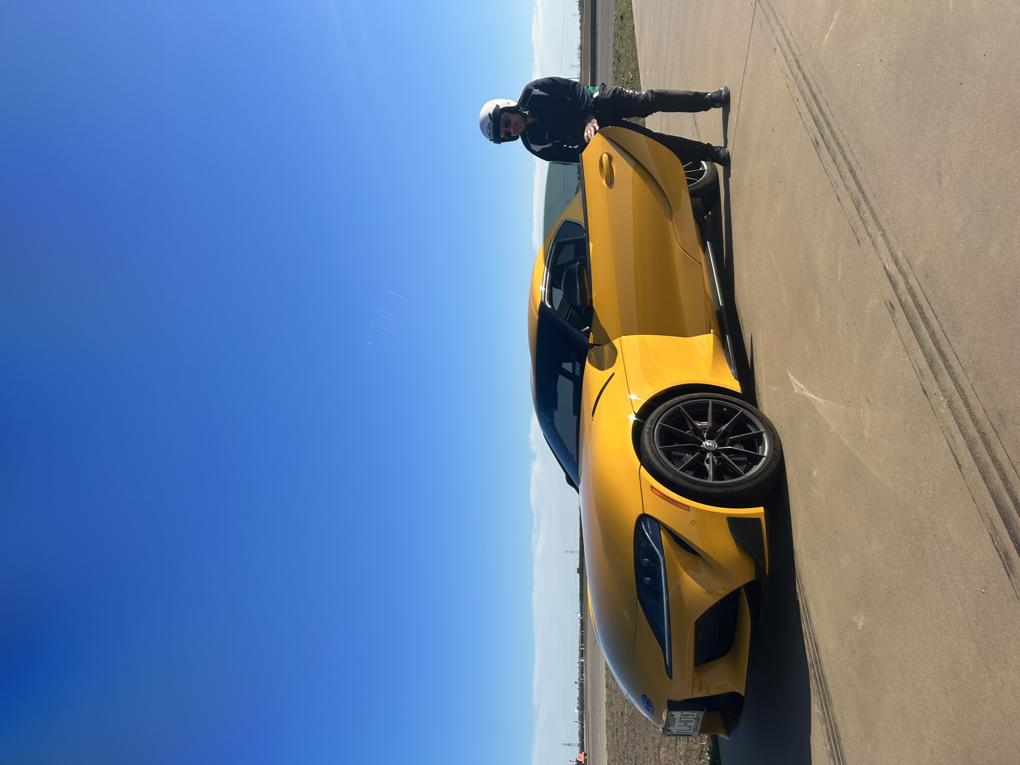 H Jafari standing next to a yellow Toyota Supra on a race track