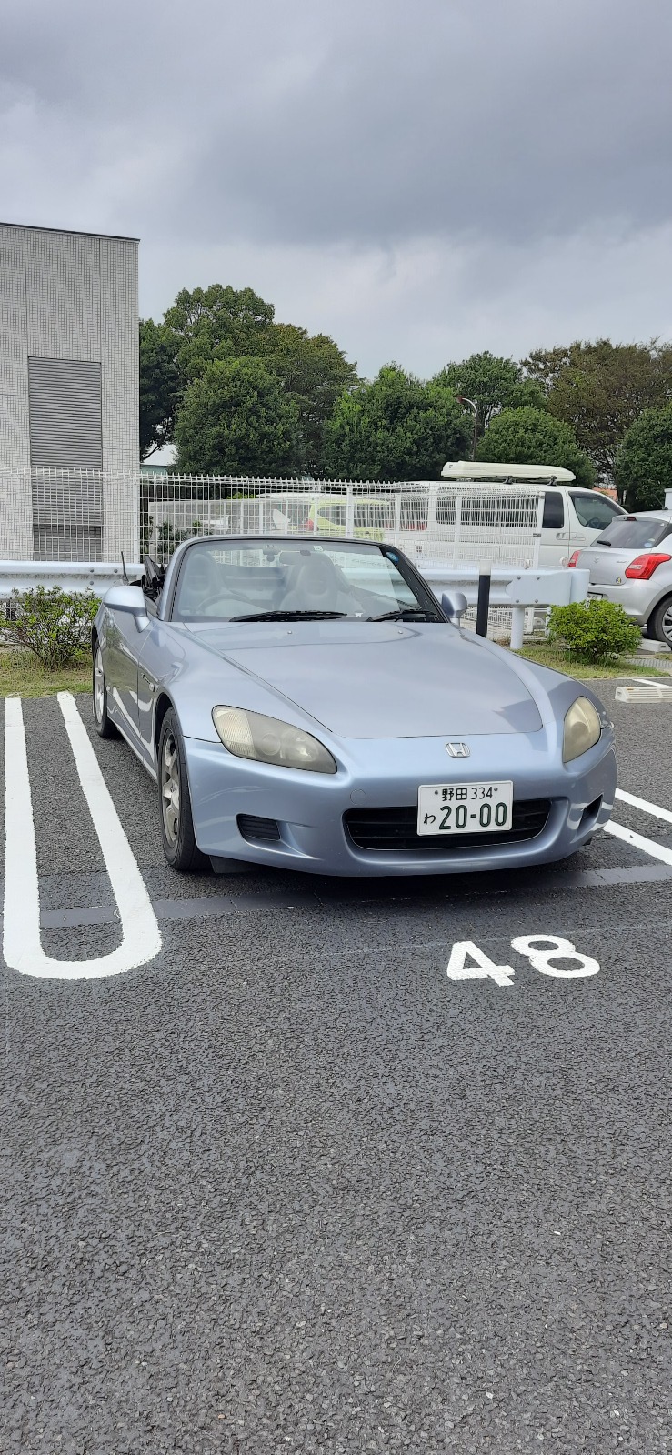 A silver Honda S2000 parked in a parking spot, rented for the trip
