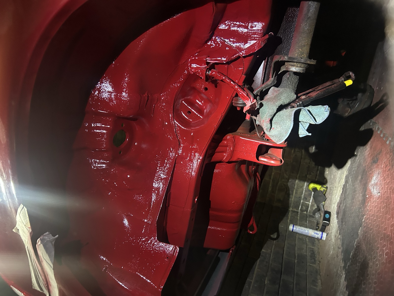 A KW V3 coilover installed in the car, wrapped in a black protective sock, underside view