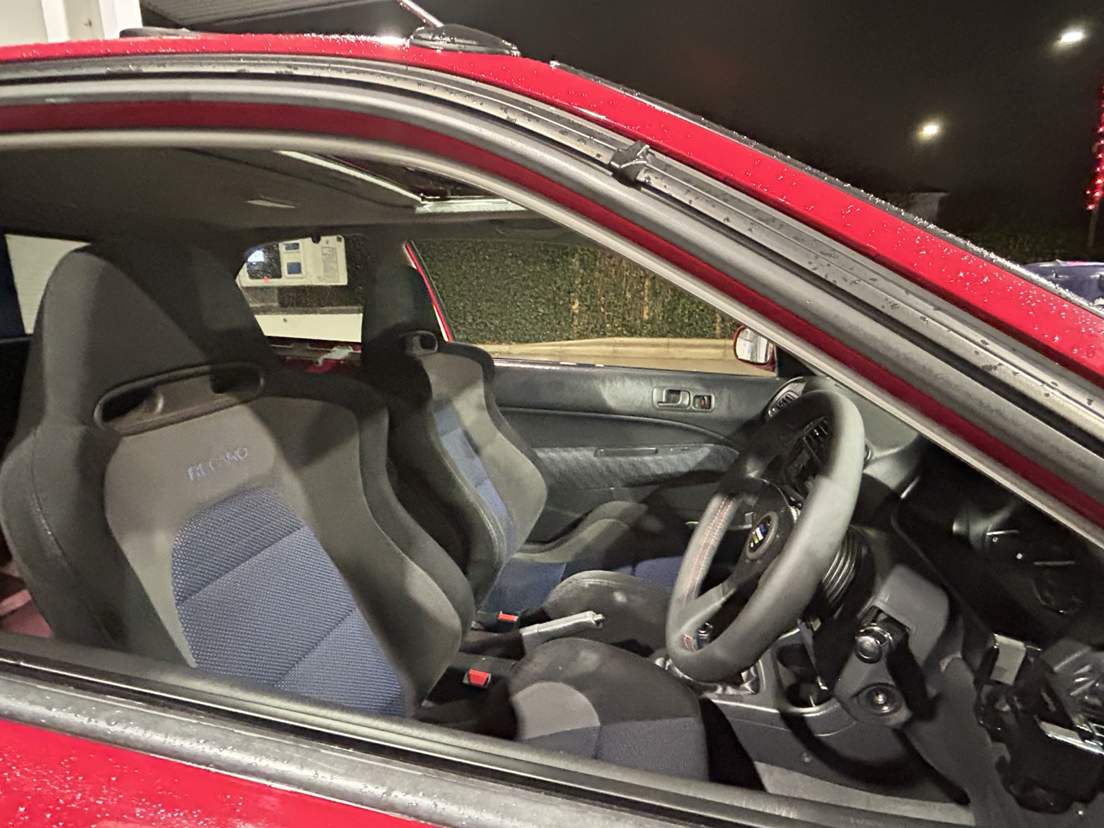 Daytime view into the Civic EK showing the finished interior with bucket seats and Spoon steering wheel