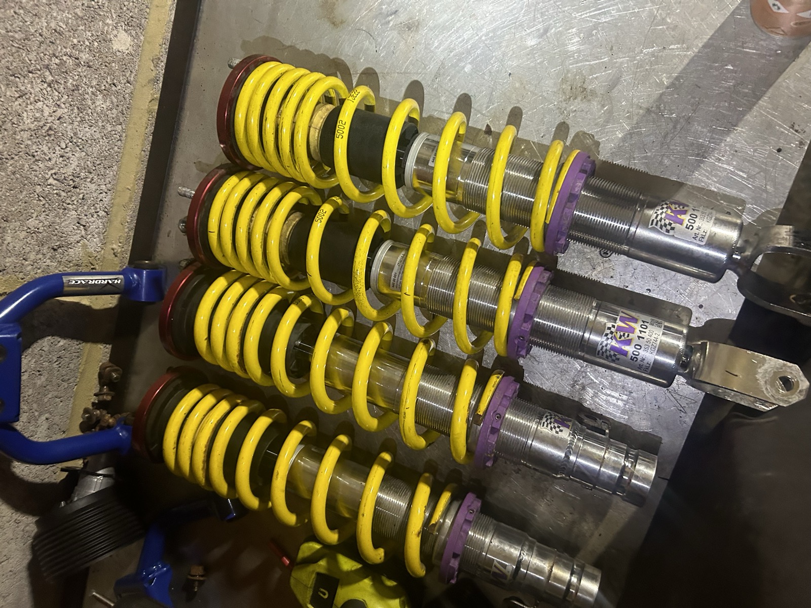 A set of KW V3 coilovers with yellow springs, laid out ready for installation